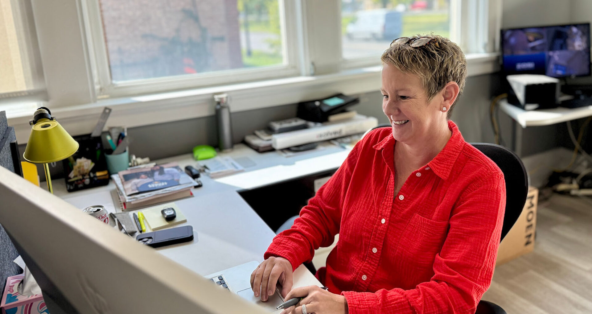 Nonprofit staff member smiling while using GiveRise on a laptop